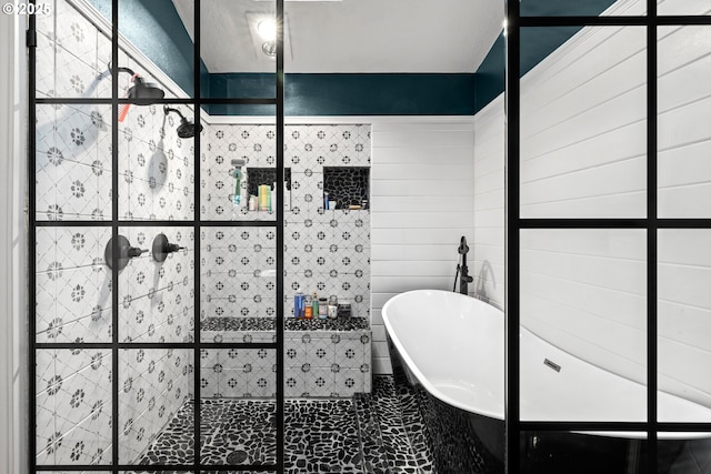 full bathroom with tile walls, a tile shower, and a freestanding bath