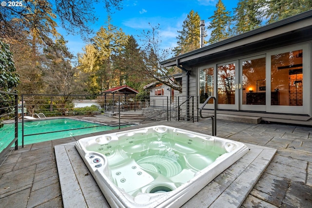 view of pool featuring a fenced in pool, hot tub deck surround, a patio, and fence