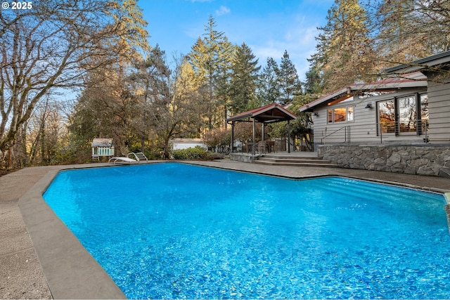 pool featuring a diving board and a gazebo