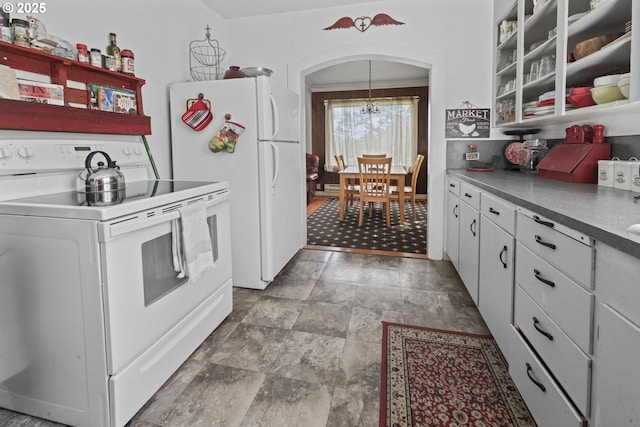 5450 Mill Creek Rd, The Dalles, OR 97058 - kitchen featuring white appliances, arched walkways, stone finish flooring, open shelves, and white cabinetry