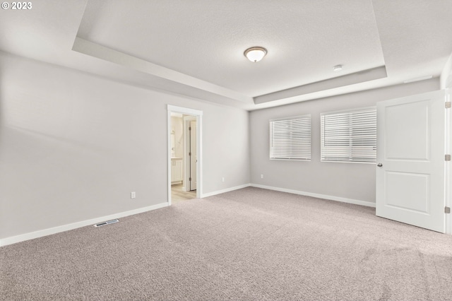 3020 S Kodiak St Unit Lt811, Cornelius, OR 97113 - unfurnished bedroom featuring a tray ceiling, light carpet, a textured ceiling, and ensuite bathroom