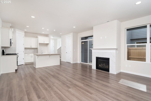 3020 S Kodiak St Unit Lt811, Cornelius, OR 97113 - unfurnished living room featuring recessed lighting, wood finished floors, and a high end fireplace