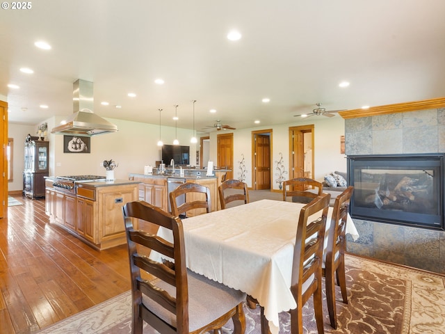 dining room featuring recessed lighting, ceiling fan, hardwood / wood-style floors, and a fireplace