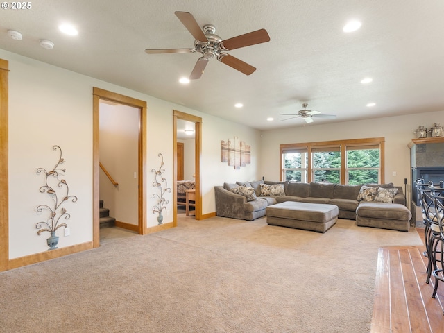 living room with recessed lighting, a ceiling fan, carpet, and stairway