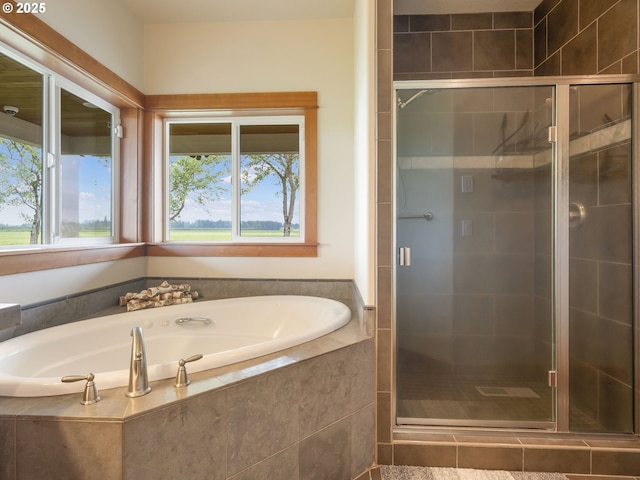 full bathroom featuring a bath and a shower stall