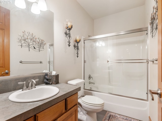 bathroom with vanity, enclosed tub / shower combo, and toilet