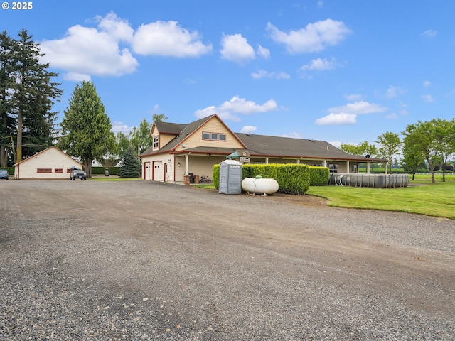 farmhouse featuring a garage, driveway, and a front lawn