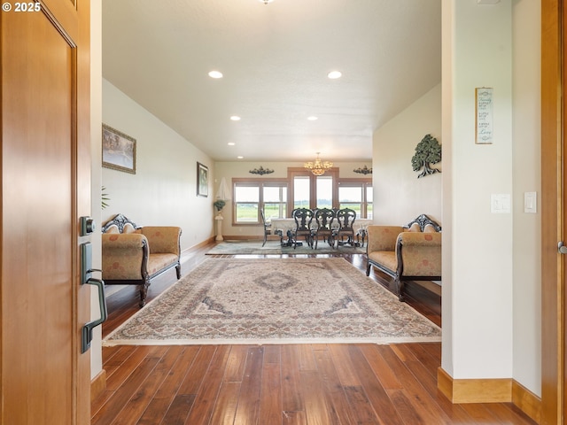 living area with baseboards, recessed lighting, wood finished floors, and a chandelier