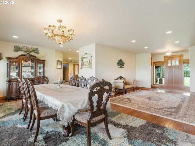 dining space with baseboards, recessed lighting, wood finished floors, and a notable chandelier