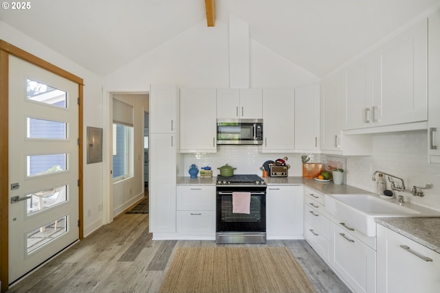 7228 N Villard Ave, Portland, OR 97217 - kitchen featuring appliances with stainless steel finishes, electric panel, light wood finished floors, white cabinetry, and beam ceiling