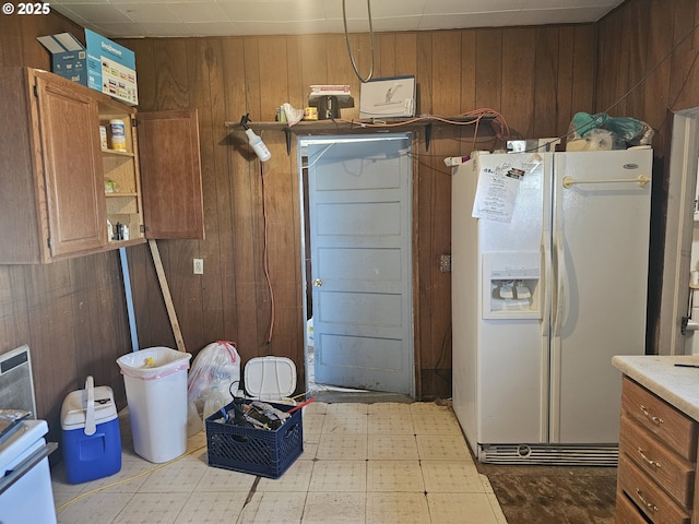54901 Willow St, Heppner, OR 97836 - kitchen featuring white refrigerator with ice dispenser, wooden walls, brown cabinetry, and light countertops