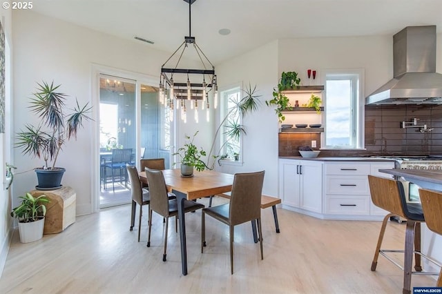 dining space featuring a chandelier, visible vents, and light wood-type flooring