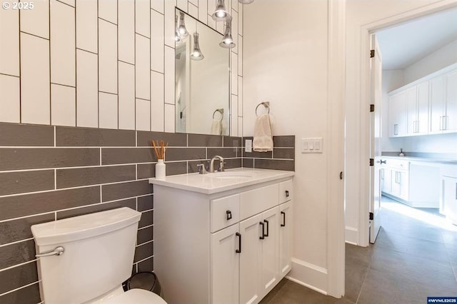 bathroom featuring tile patterned floors, toilet, tasteful backsplash, tile walls, and vanity