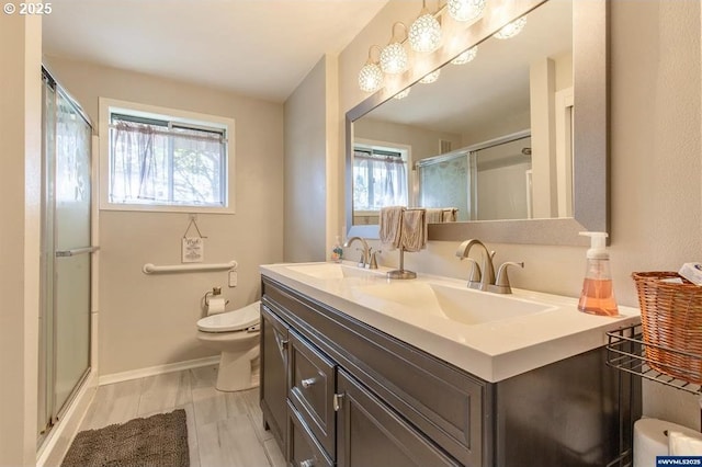 bathroom featuring double vanity, a shower stall, toilet, and a sink