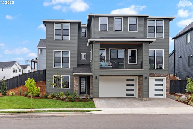 310 W Fir Loop, Washougal, WA 98671 - view of front of house featuring concrete driveway, a garage, stone siding, and a balcony
