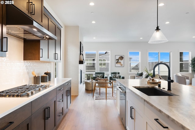 310 W Fir Loop, Washougal, WA 98671 - kitchen featuring a sink, open floor plan, appliances with stainless steel finishes, under cabinet range hood, and dark brown cabinetry