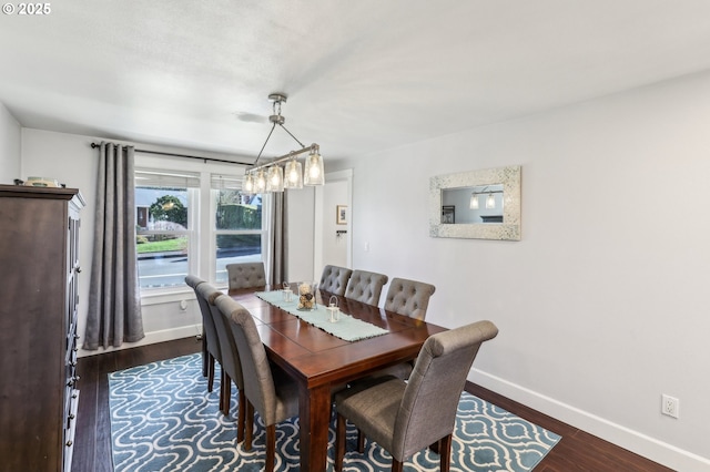 dining room with dark wood-type flooring and baseboards