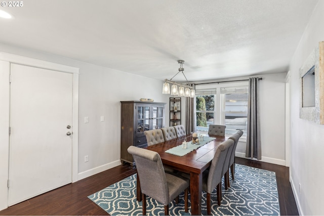 dining space featuring baseboards, a textured ceiling, and wood finished floors