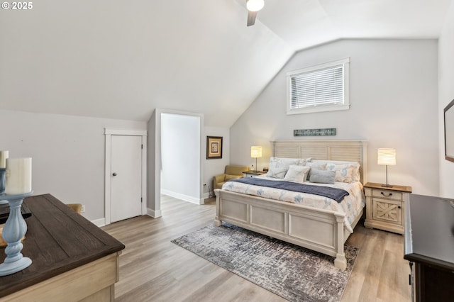 bedroom featuring baseboards, lofted ceiling, light wood-style floors, and a ceiling fan