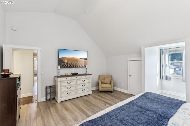 bedroom featuring lofted ceiling, light wood-style floors, and baseboards