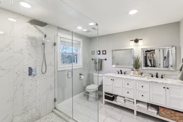 full bath featuring a sink, a shower stall, marble finish floor, and double vanity