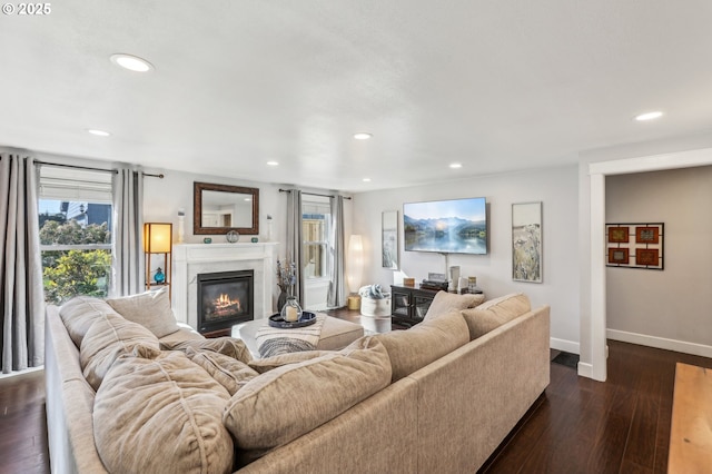 living room with recessed lighting, a high end fireplace, baseboards, and dark wood-style flooring