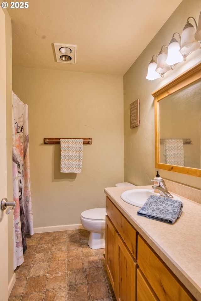 full bathroom with baseboards, toilet, and vanity