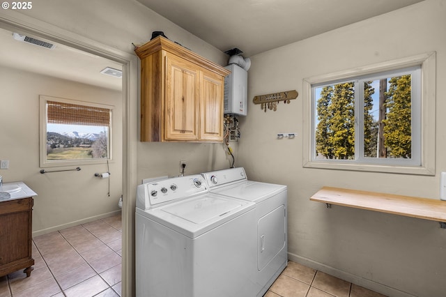 washroom with visible vents, washer and dryer, water heater, cabinet space, and light tile patterned flooring