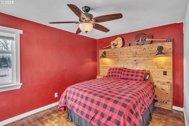 bedroom with a ceiling fan, baseboards, and wood finished floors