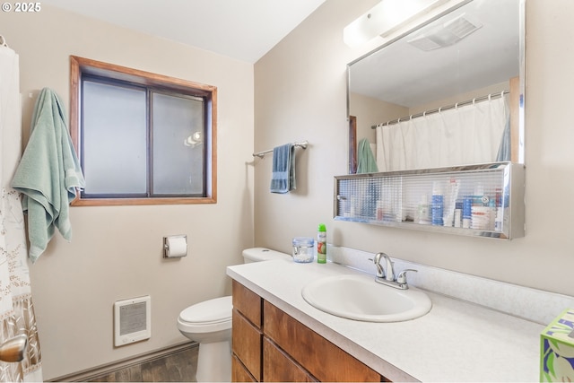 full bath featuring visible vents, toilet, wood finished floors, heating unit, and vanity