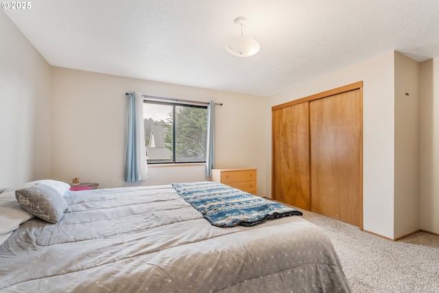 carpeted bedroom featuring baseboards and a closet