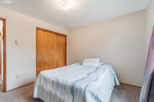 carpeted bedroom featuring a closet, baseboards, and a textured ceiling