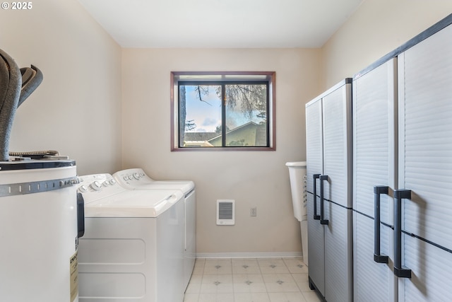 washroom featuring visible vents, electric water heater, baseboards, laundry area, and washer and dryer