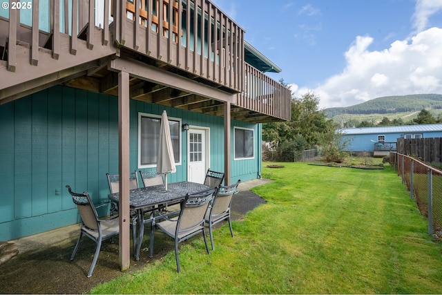 view of yard featuring outdoor dining space, a mountain view, and a fenced backyard