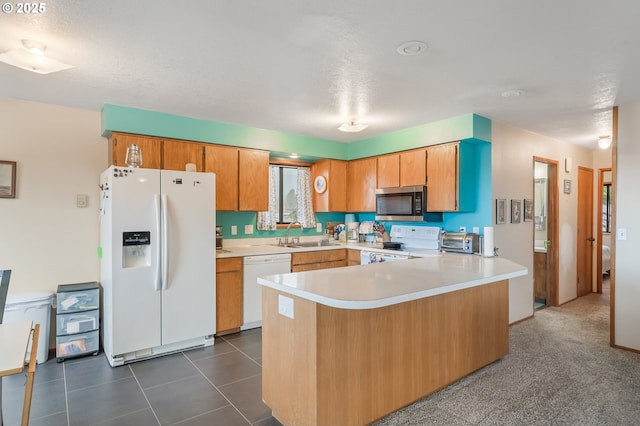 kitchen featuring a sink, white appliances, a peninsula, a toaster, and light countertops