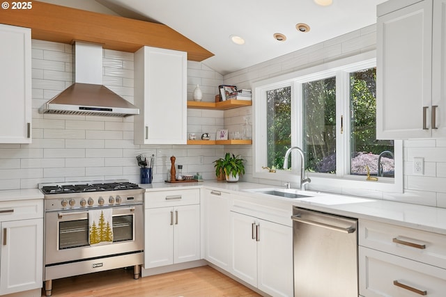 8895 SW Bohmann Pkwy, Portland, OR 97223 - kitchen featuring appliances with stainless steel finishes, wall chimney range hood, vaulted ceiling, a sink, and decorative backsplash