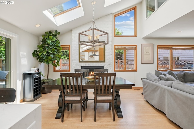 8895 SW Bohmann Pkwy, Portland, OR 97223 - dining area with light wood finished floors, high vaulted ceiling, a skylight, a large fireplace, and baseboards