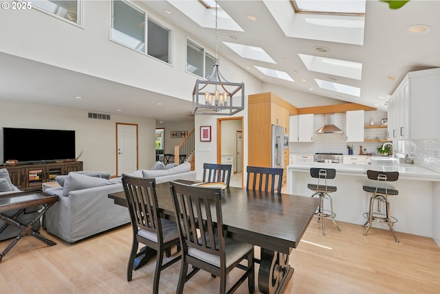 8895 SW Bohmann Pkwy, Portland, OR 97223 - dining room featuring light wood-type flooring, a chandelier, a skylight, and recessed lighting