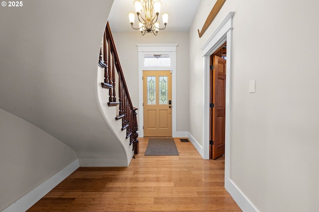 entryway featuring an inviting chandelier and light hardwood / wood-style flooring