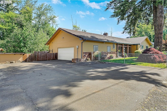 view of front of property featuring a fenced front yard, a chimney, a gate, and a detached garage