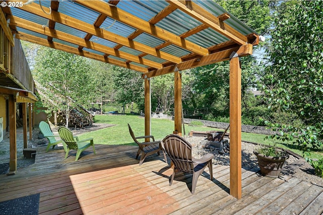 wooden deck featuring a fire pit, a lawn, and a pergola