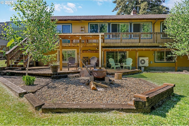 rear view of property with a wooden deck, stairway, a chimney, a yard, and a cooling unit