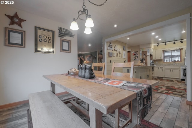 dining area with light wood-style floors, baseboards, track lighting, and recessed lighting