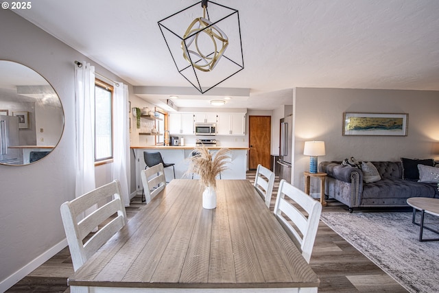 3308 Honeywood St, Eugene, OR 97408 - dining area featuring dark wood-style floors, baseboards, and a chandelier