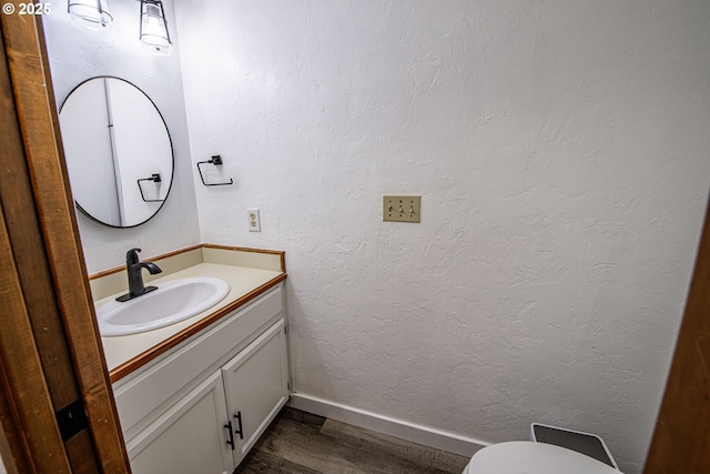3308 Honeywood St, Eugene, OR 97408 - half bathroom with wood finished floors, vanity, baseboards, and toilet
