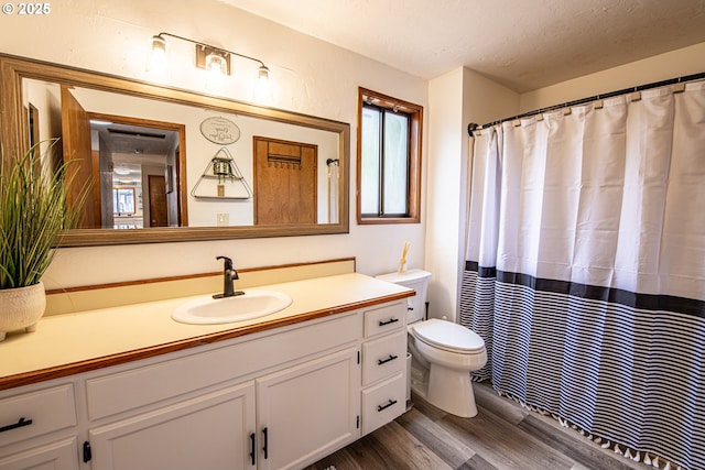 3308 Honeywood St, Eugene, OR 97408 - bathroom featuring wood finished floors, vanity, toilet, and a textured ceiling