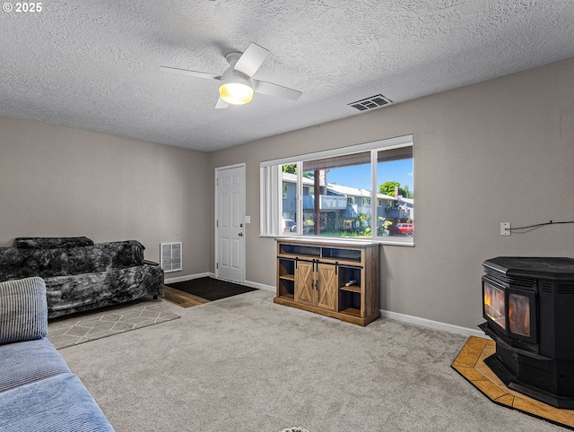 3311 SE 1st St, Gresham, OR 97080 - living room featuring a wood stove, baseboards, carpet floors, ceiling fan, and a textured ceiling