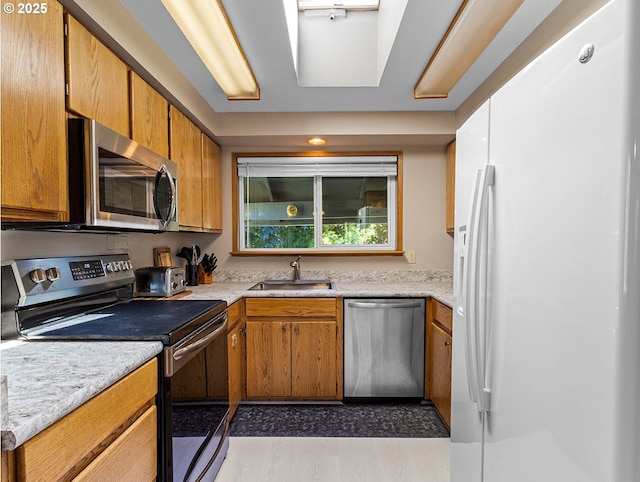 3311 SE 1st St, Gresham, OR 97080 - kitchen with appliances with stainless steel finishes, a sink, light countertops, and brown cabinets