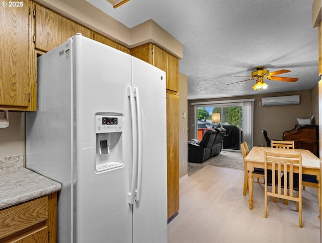 3311 SE 1st St, Gresham, OR 97080 - kitchen featuring white fridge with ice dispenser, a wall mounted AC, light wood finished floors, ceiling fan, and light countertops