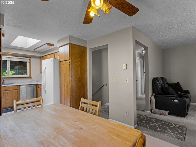 3311 SE 1st St, Gresham, OR 97080 - carpeted dining area with a skylight, a textured ceiling, a sink, ceiling fan, and baseboards
